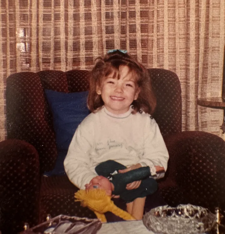 Mery Calvo de pequeña, sonriendo en el sillón de casa
