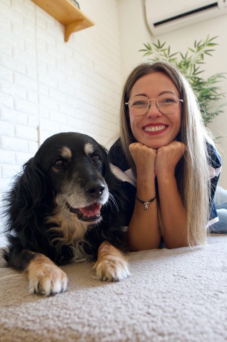 Mery Calvo junto a Noa, su perra senior, sonriendo en casa