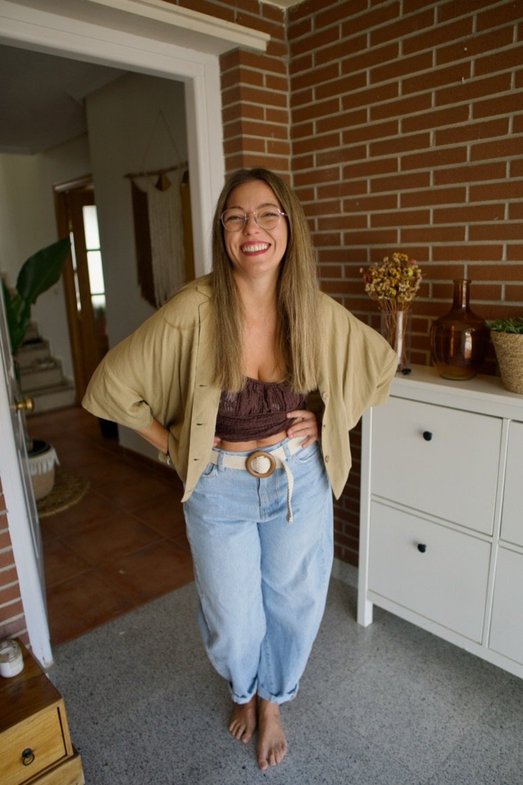 Mery Calvo sonriendo en casa, apoyada en una pared de ladrillo